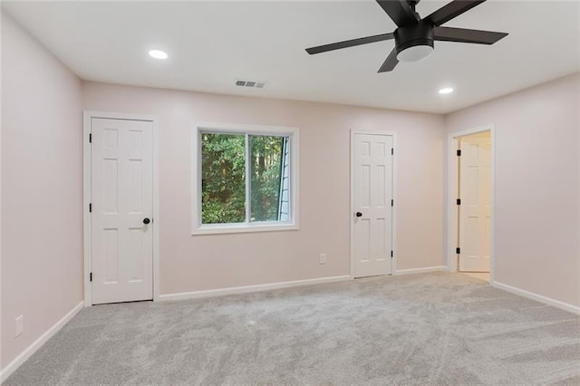 spare room with carpet flooring, baseboards, visible vents, and ceiling fan