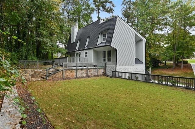 back of property with stairway, a chimney, and a yard