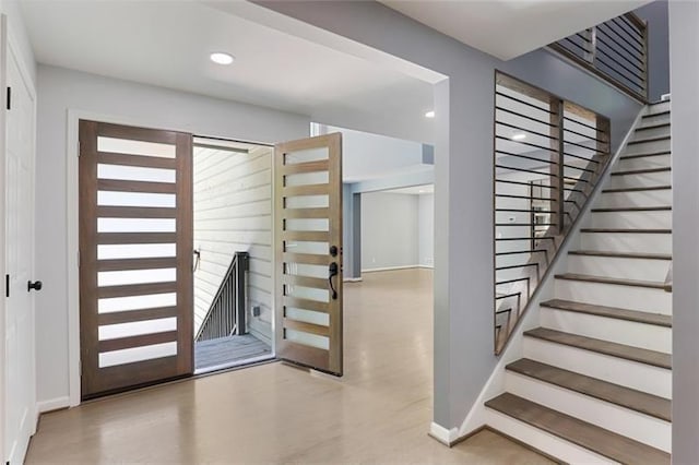 stairway with recessed lighting, wood finished floors, and baseboards