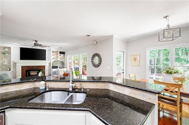 1558 Amberwood Creek Dr NW, Kennesaw, GA 30152 - kitchen featuring ceiling fan, plenty of natural light, white cabinetry, a fireplace, and crown molding