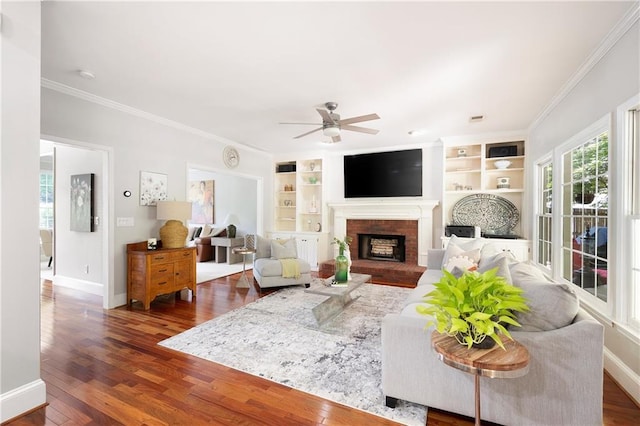 1558 Amberwood Creek Dr NW, Kennesaw, GA 30152 - living room with ceiling fan, crown molding, built in shelves, a brick fireplace, and dark wood-style flooring