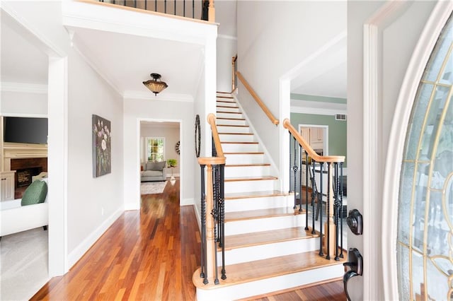 1558 Amberwood Creek Dr NW, Kennesaw, GA 30152 - foyer entrance with wood finished floors, stairs, crown molding, and a fireplace