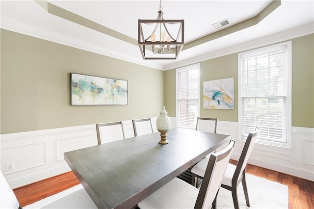 1558 Amberwood Creek Dr NW, Kennesaw, GA 30152 - dining area featuring a chandelier, a raised ceiling, wood finished floors, wainscoting, and crown molding