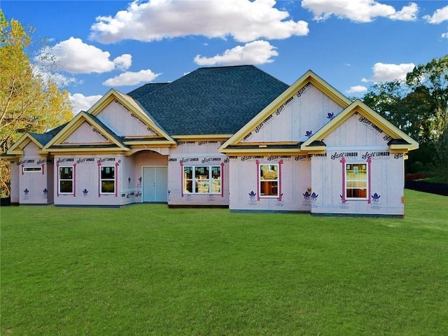 back of house featuring a shingled roof, a lawn, and board and batten siding