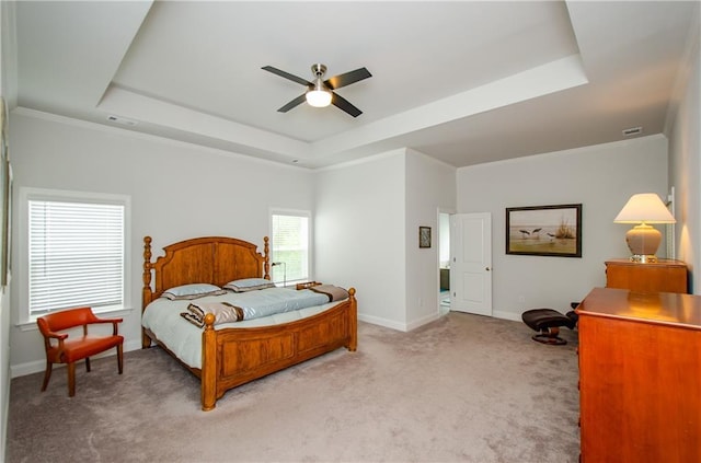 carpeted bedroom with crown molding, ceiling fan, and a tray ceiling