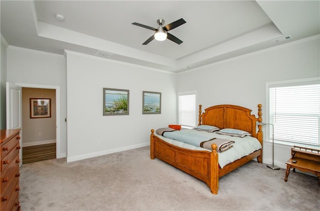 bedroom featuring ceiling fan, light colored carpet, ornamental molding, and a raised ceiling