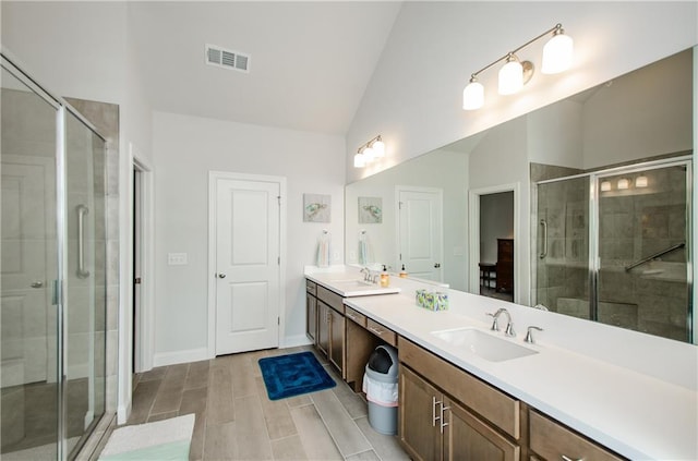 bathroom with vanity, vaulted ceiling, and walk in shower