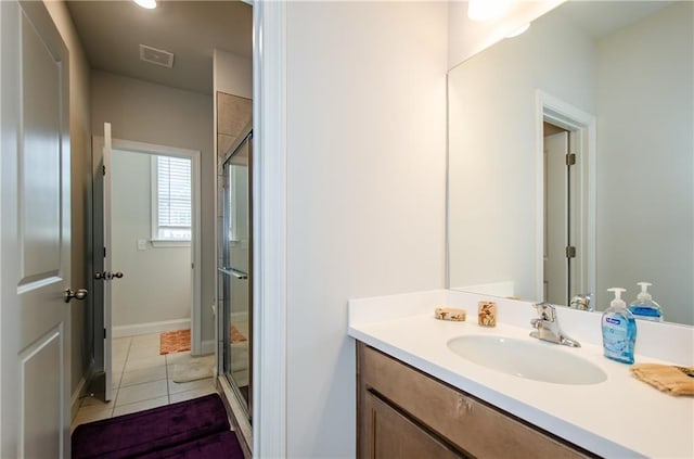 bathroom with an enclosed shower, vanity, and tile patterned flooring