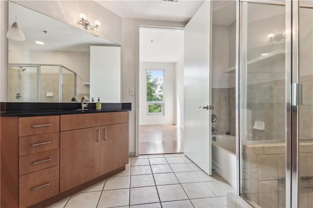 bathroom with tile patterned flooring, shower with separate bathtub, and vanity