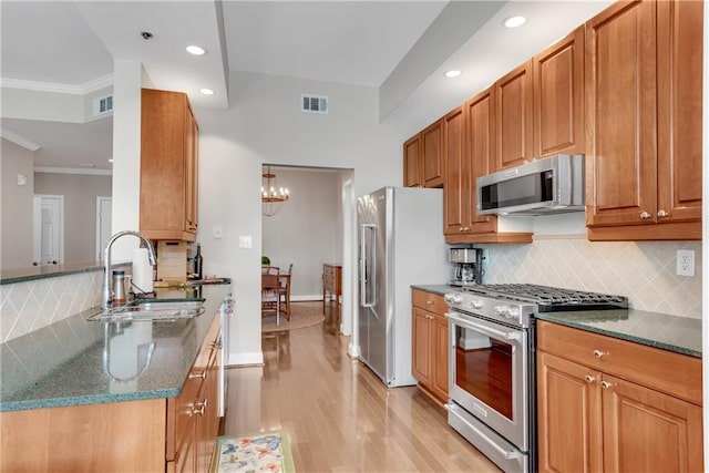 kitchen featuring crown molding, light hardwood / wood-style floors, a chandelier, sink, and high quality appliances