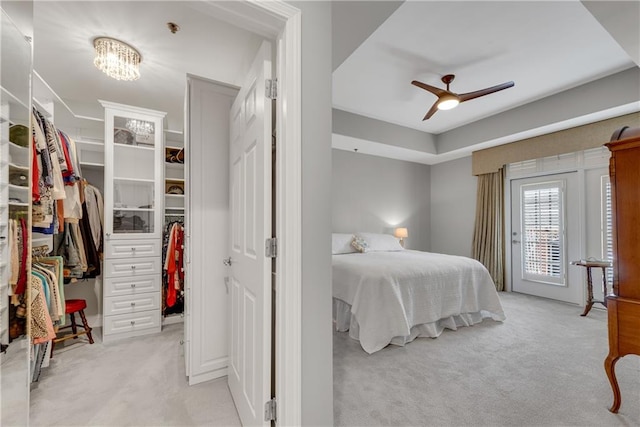 carpeted bedroom with a closet and ceiling fan with notable chandelier