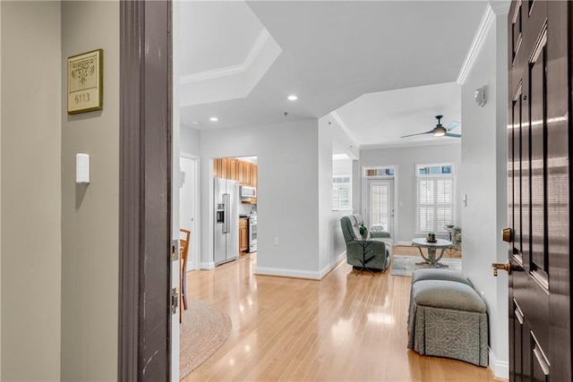 entryway with ceiling fan, crown molding, and light hardwood / wood-style flooring