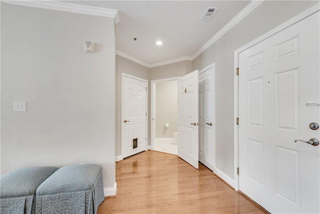 hallway featuring ornamental molding and light hardwood / wood-style floors