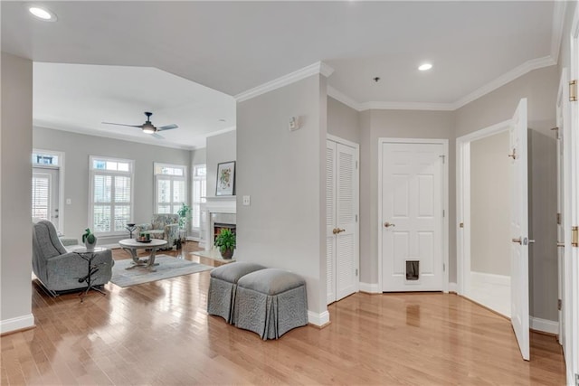 interior space with light hardwood / wood-style flooring, ceiling fan, and ornamental molding