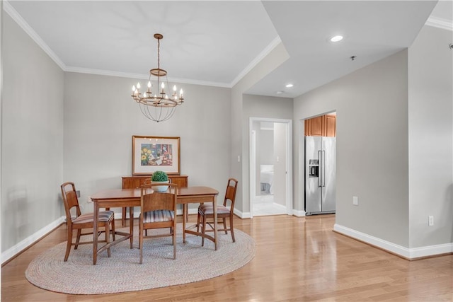 dining area featuring light wood-type flooring, crown molding, and a chandelier