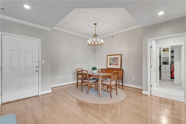 dining room featuring light wood-type flooring, crown molding, and a notable chandelier