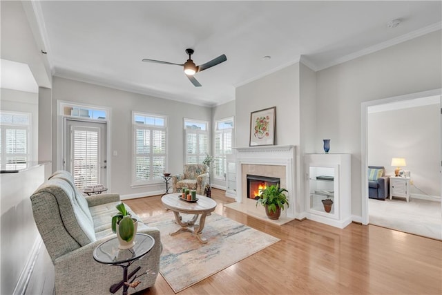 living room featuring crown molding, light hardwood / wood-style flooring, and ceiling fan