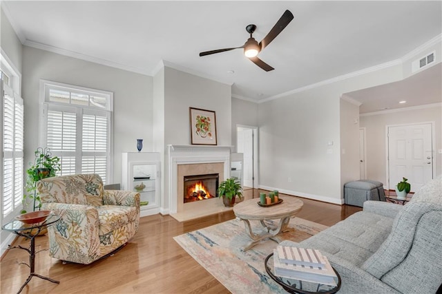 living room featuring crown molding, light hardwood / wood-style flooring, and ceiling fan