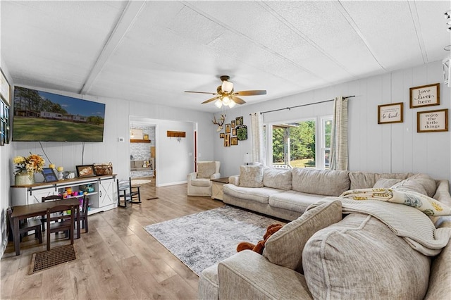 living room featuring a textured ceiling, ceiling fan, and light hardwood / wood-style flooring