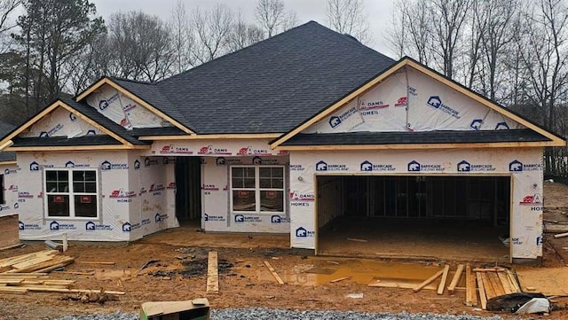 property under construction with an attached garage and a shingled roof