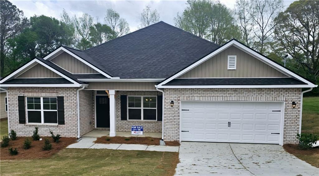 craftsman house featuring concrete driveway, brick siding, a front lawn, and an attached garage
