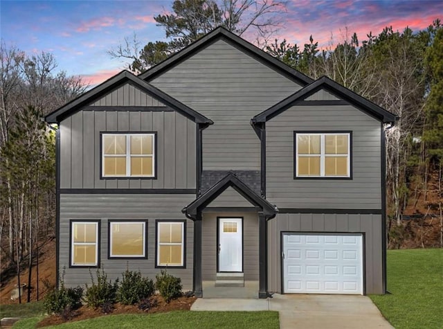 view of front of home with a garage, a yard, board and batten siding, and driveway