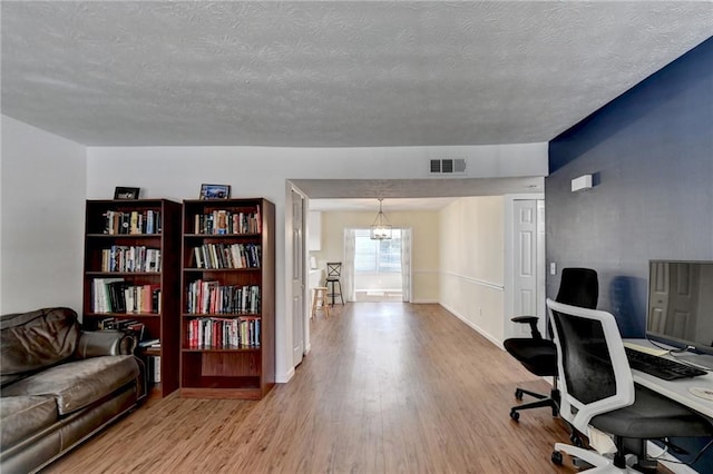 office space featuring light hardwood / wood-style flooring and a textured ceiling