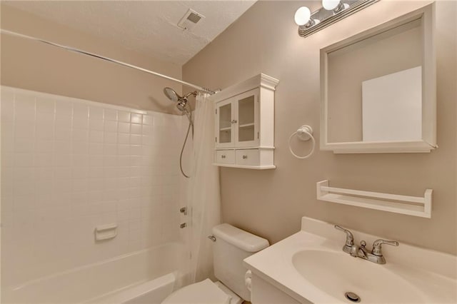 full bathroom with toilet, vanity, a textured ceiling, and tiled shower / bath