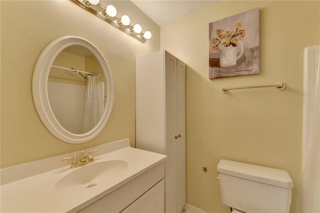 bathroom featuring a shower with curtain, vanity, and toilet