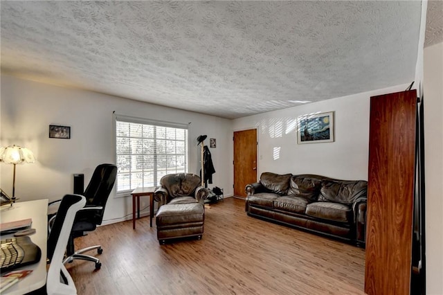 office area with light hardwood / wood-style flooring and a textured ceiling