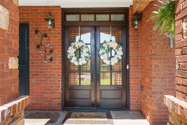 property entrance featuring french doors and brick siding