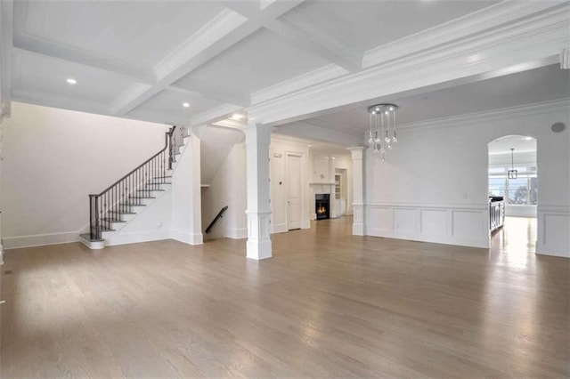 unfurnished living room featuring beamed ceiling, coffered ceiling, and hardwood / wood-style floors