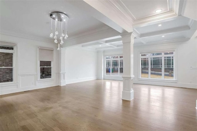 unfurnished living room with beam ceiling, crown molding, decorative columns, and hardwood / wood-style flooring