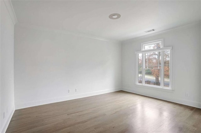 empty room featuring crown molding and dark wood-type flooring