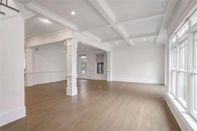 unfurnished living room with dark wood-type flooring, coffered ceiling, ornamental molding, beamed ceiling, and ornate columns