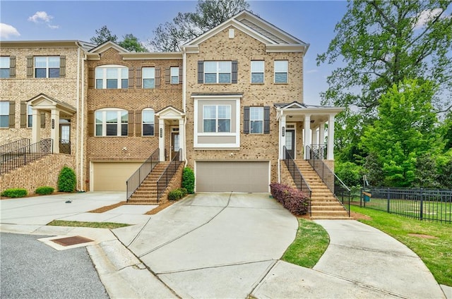 view of front of property featuring stairway, a garage, driveway, and fence