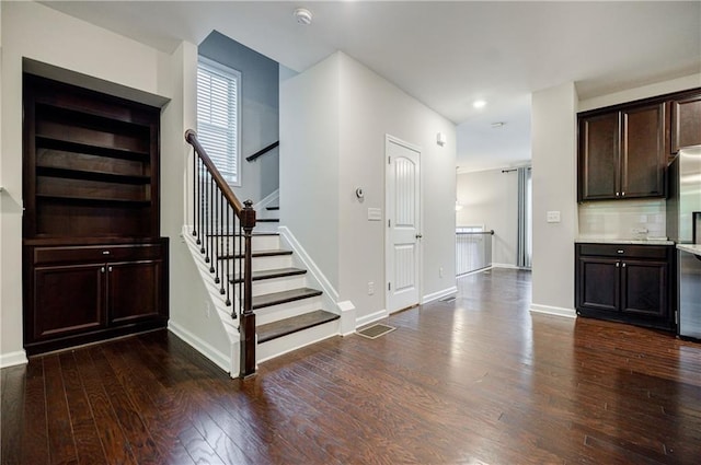 stairs featuring wood finished floors, baseboards, and recessed lighting