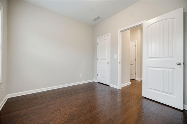 unfurnished bedroom with dark wood-style flooring and baseboards