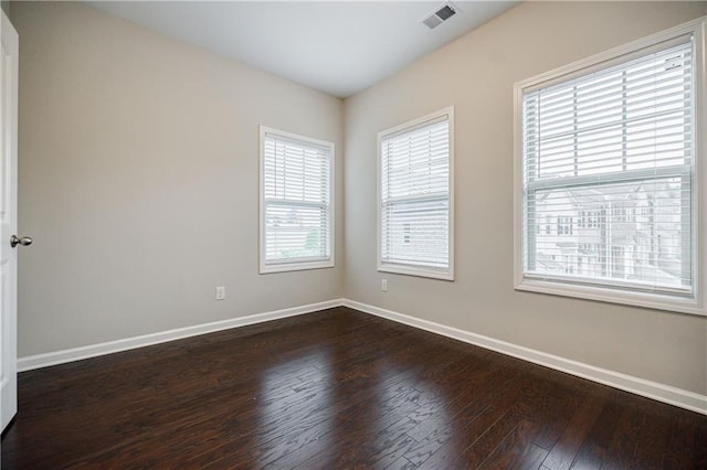 empty room featuring dark wood-type flooring and baseboards
