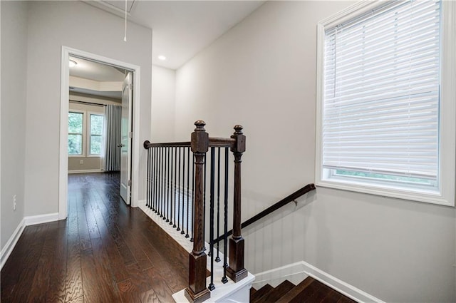 stairway featuring attic access, baseboards, and hardwood / wood-style floors