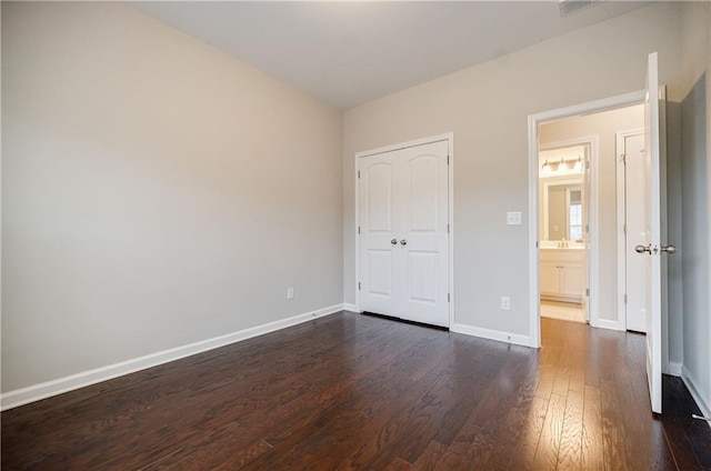 unfurnished bedroom featuring dark wood-style flooring and baseboards