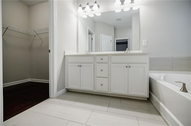 bathroom featuring double vanity, a garden tub, and a walk in closet