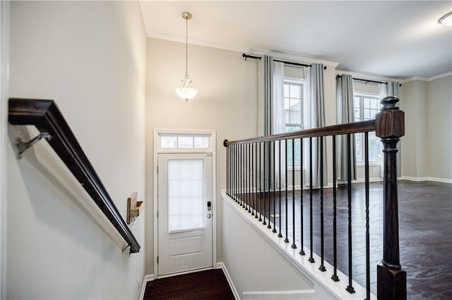 doorway to outside featuring baseboards, plenty of natural light, and crown molding