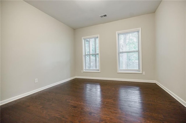 unfurnished room with dark wood-style floors and baseboards