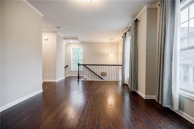 spare room featuring wood-type flooring, ornamental molding, and baseboards