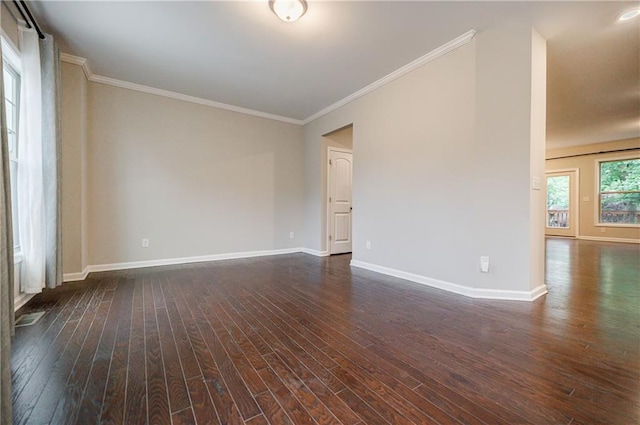 spare room with dark wood-style flooring, baseboards, and crown molding