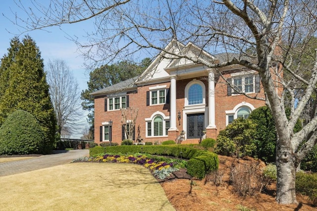 neoclassical / greek revival house featuring brick siding