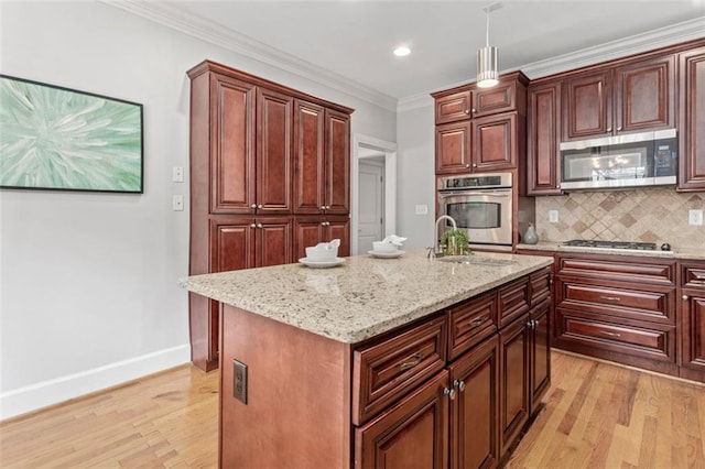 kitchen with light wood-type flooring, tasteful backsplash, an island with sink, and stainless steel appliances