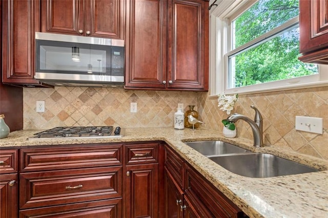 kitchen with light stone countertops, tasteful backsplash, stainless steel appliances, and a wealth of natural light