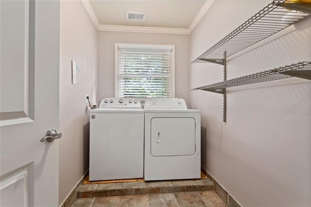 washroom featuring separate washer and dryer, ornamental molding, and dark tile floors